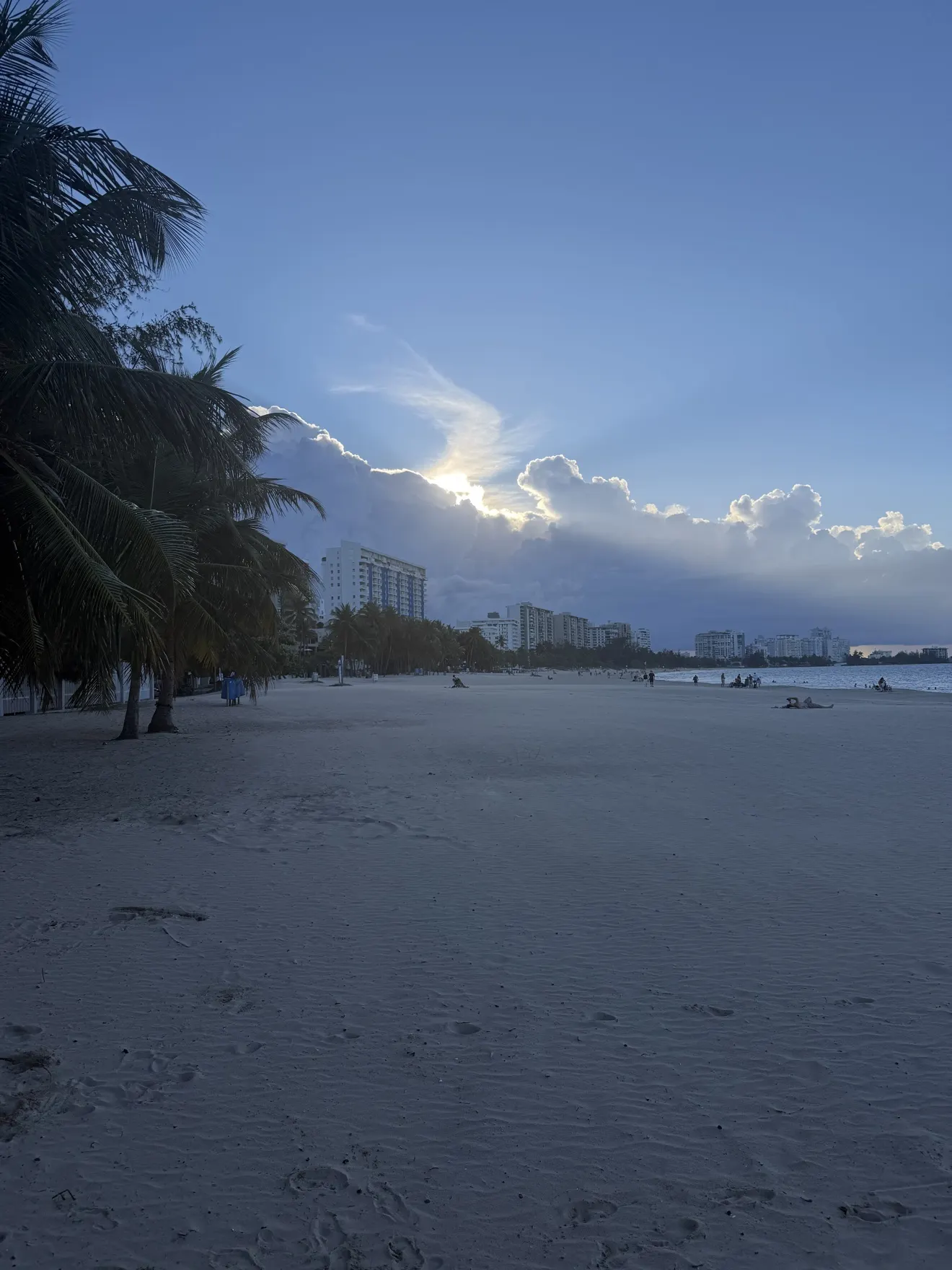 Palm-lined Isla Verde beach beneath an evening sky